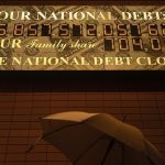 Illuminated National Debt Clock reading over $35 trillion, symbolizing financial strain intensified by Trump-era tax cuts and deficit spending.