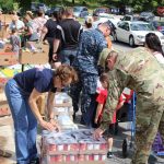 U.S. military families in uniform waiting in long line at food bank during Trump-era federal shutdown