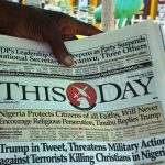 Close-up of a person holding Nigeria’s ThisDay newspaper with the headline about Trump threatening military action against Nigeria—symbolizing U.S. neo‑colonial rhetoric cloaked in religious pretense.